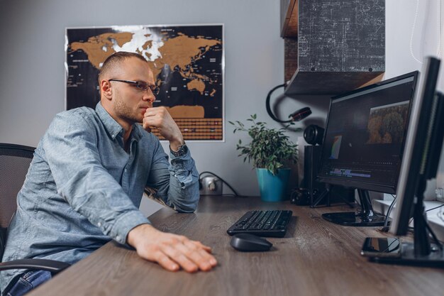 männlicher unternehmer, der an einem freiberuflichen projekt arbeitet, während er auf den computer schaut