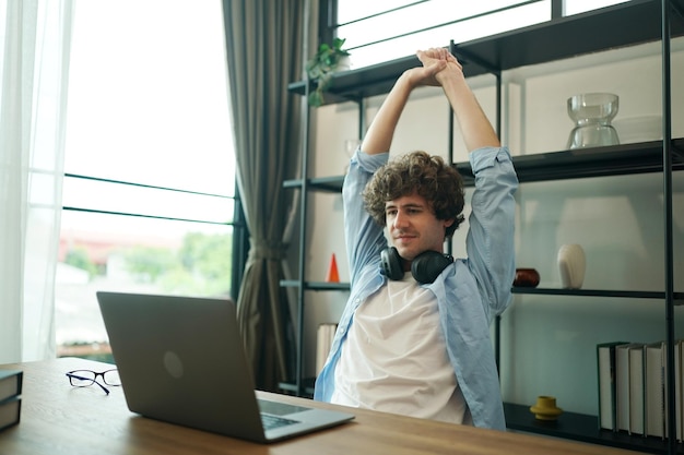 Männlicher Unternehmer zu Hause, der am Laptop arbeitet und Freizeit hat