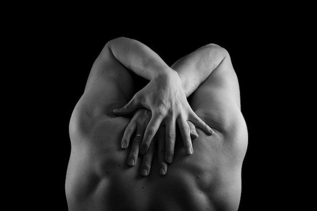 Männlicher vorbildlicher Athlet mit muskulösem sexy Körper und nacktem Rücken Man39s Rücken und Hände auf schwarzem Hintergrund Gepumpter Rücken und Arme