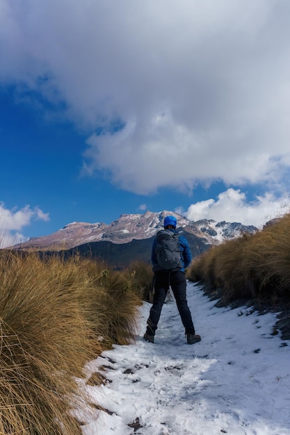 Männlicher Wanderer mit Rucksackwanderberg im Winter an sonnigen Tagen