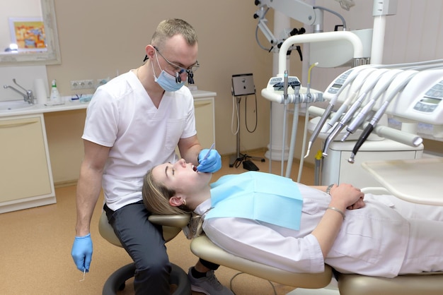 Männlicher Zahnarzt, der die Zähne eines jungen Patienten überprüft