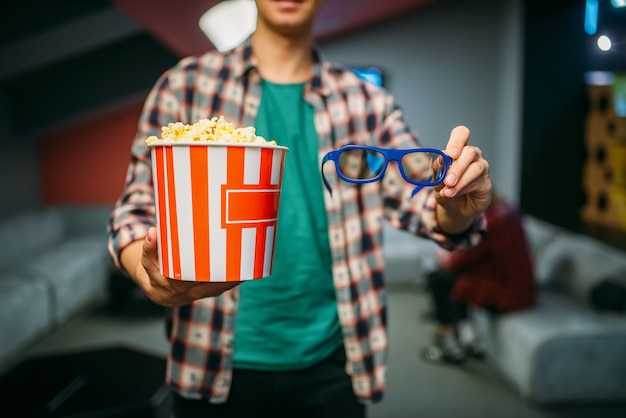 Männlicher Zuschauer mit 3D-Brille und Popcorn im Kinosaal vor der Showtime. Mann im Kino, Unterhaltungslebensstil
