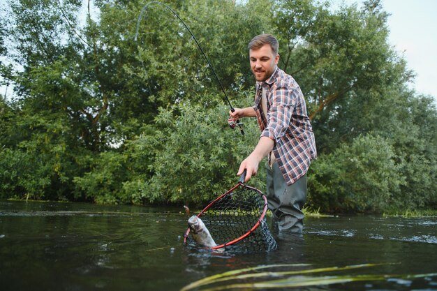 Männliches Hobby Bereit zum Fischen Entspannen Sie sich in natürlicher Umgebung Forellenköder Bärtiger eleganter Mann Man entspannender Naturhintergrund Strategie Hobby Sportaktivität Aktivität und Hobby Fangen und Angeln