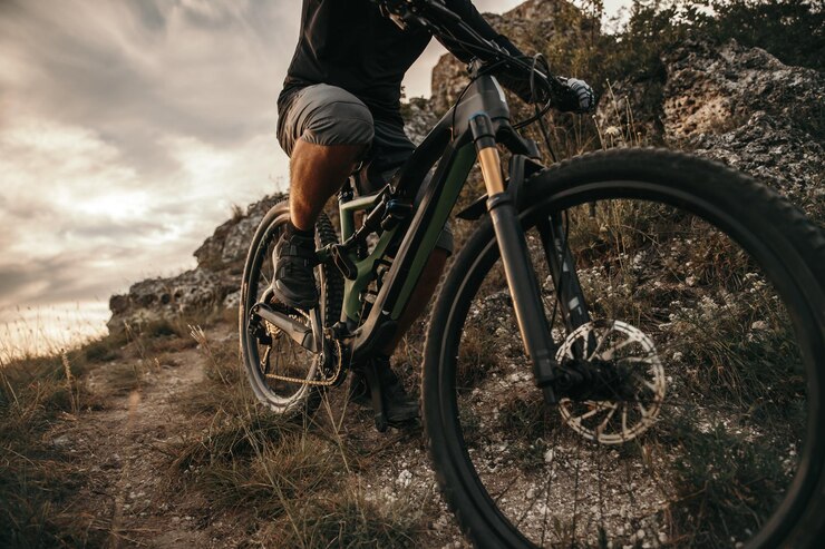 Männliches Reiten Mountainbike an bewölktem Abend