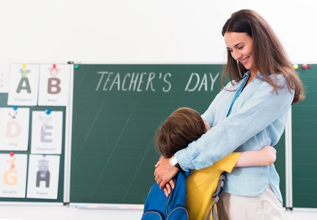 Maestra abrazando a su alumno