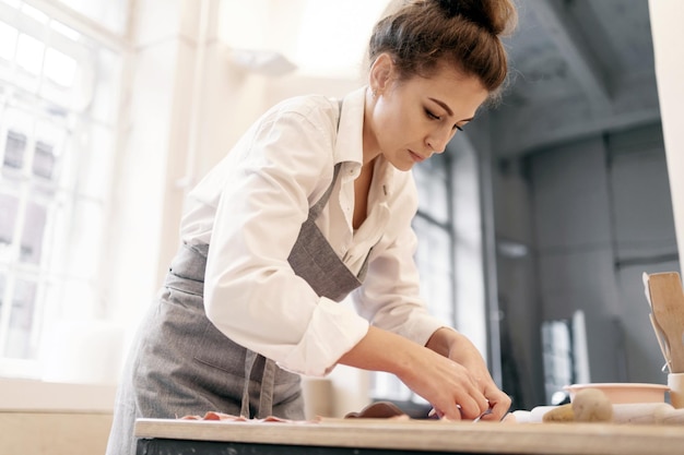 Una maestra ceramista de arcilla hace su trabajo Workshopstudio una persona hace cerámica artesanal