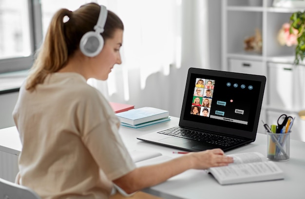 maestra con computadora portátil teniendo clase en línea