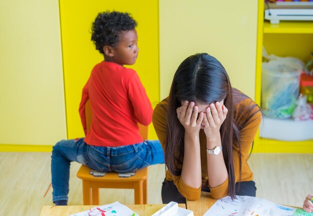 Foto maestra cubriendo la cara por un niño