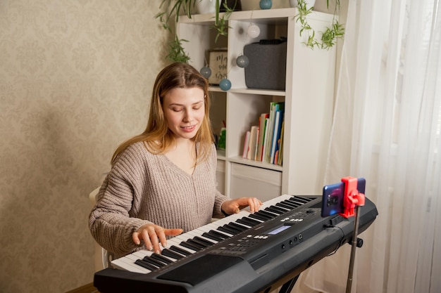 Maestra enseñando a su estudiante a tocar el piano y grabar lecciones en línea