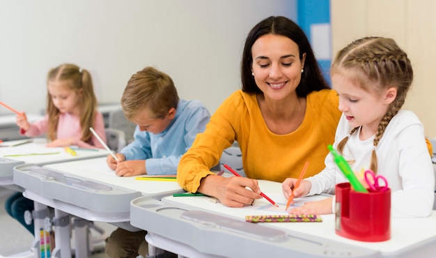 Maestra feliz ayudando a sus alumnos