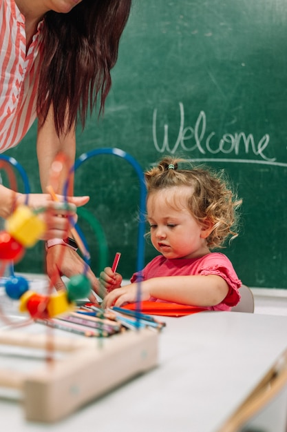 Foto maestra de jardín de infantes apoya al niño en clase