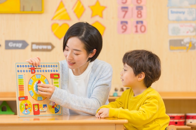 Maestra de jardín de infantes jugando con niños