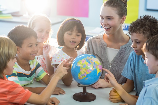 Maestra mostrando globo a los niños