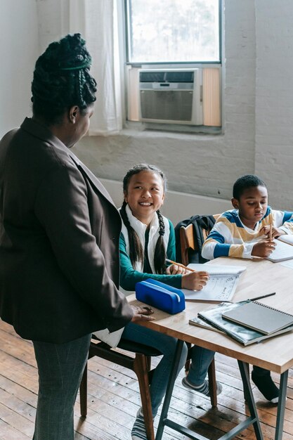 Una maestra negra hablando con alumnos multiétnicos y alegres