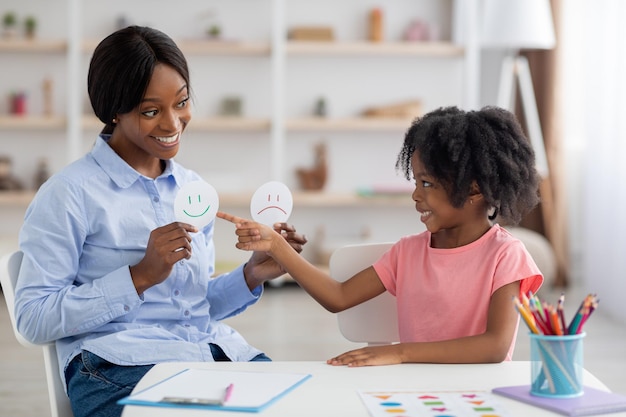 Maestra y niña negra haciendo ejercicio en la guardería