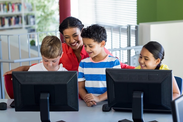 Maestra con niños durante la clase de computación