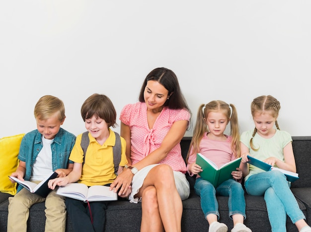 Foto maestra y niños sentados juntos