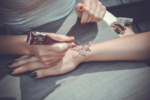 La maestra pinta su mano con henna mehendi en estilos
