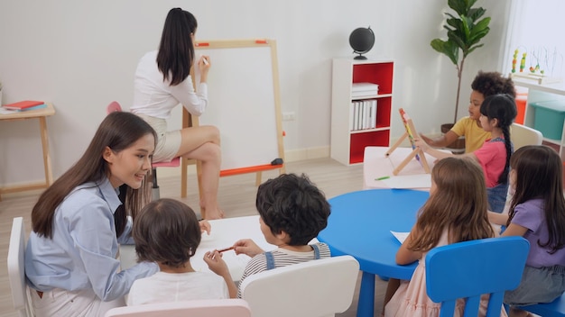 Maestra de preescolar con niños estudian en el aula. jardín de infantes regreso a la escuela