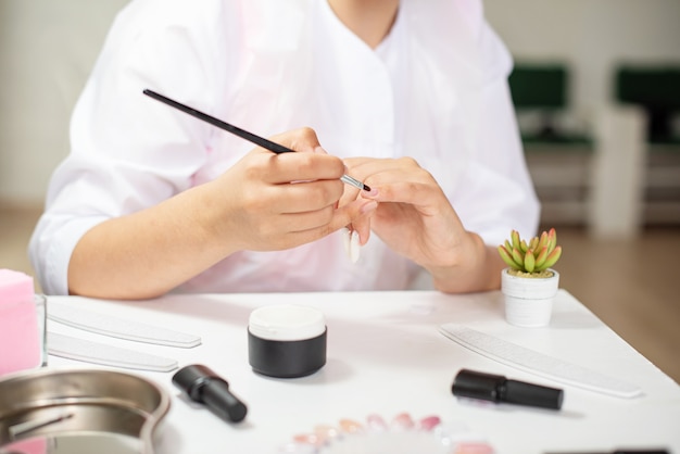 Maestra realizando una manicura profesional en sí misma en un salón de belleza, curso de manicura, blogs