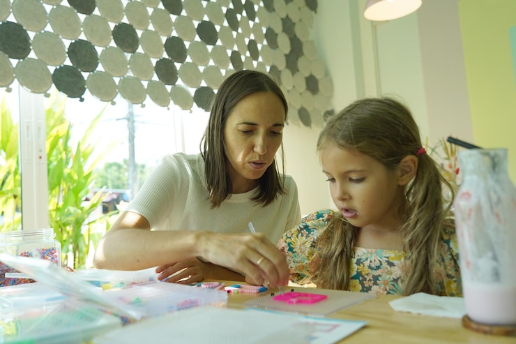 Foto la maestra en el taller enseñó a dos chicas cómo montar un termo mosaico.