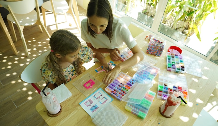 Foto la maestra en el taller enseñó a dos chicas cómo montar un termo mosaico.