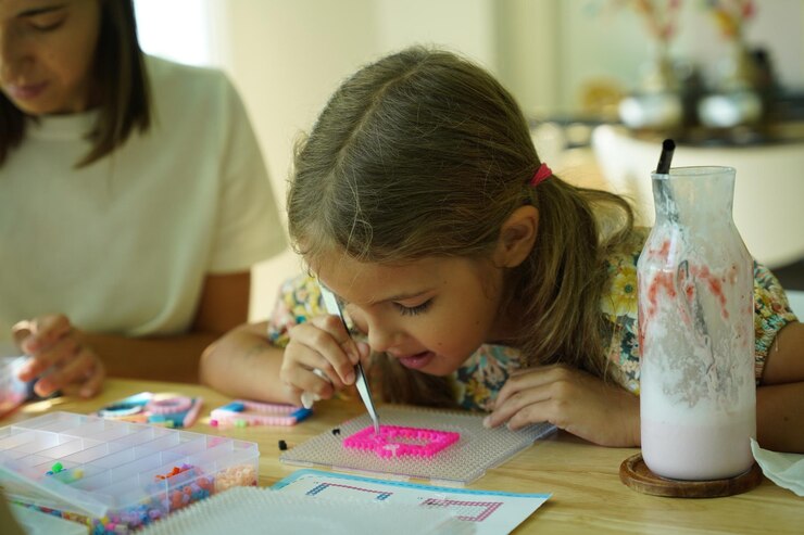Foto la maestra en el taller enseñó a dos chicas cómo montar un termo mosaico.
