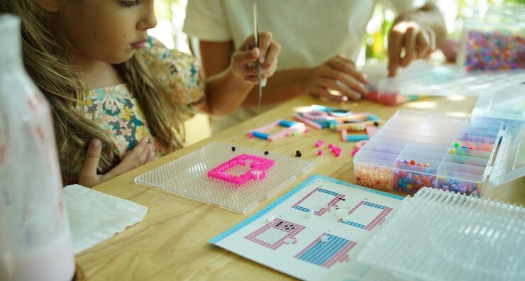 Foto la maestra en el taller enseñó a dos chicas cómo montar un termo mosaico.