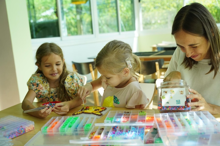 Foto la maestra en el taller enseñó a dos chicas cómo montar un termo mosaico.