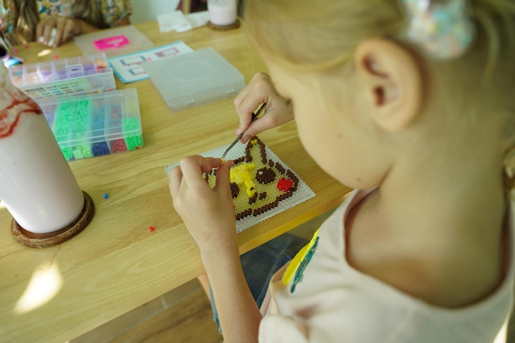 Foto la maestra en el taller enseñó a dos chicas cómo montar un termo mosaico.