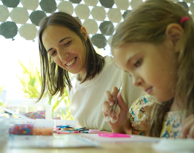 Foto la maestra en el taller enseñó a dos chicas cómo montar un termo mosaico.