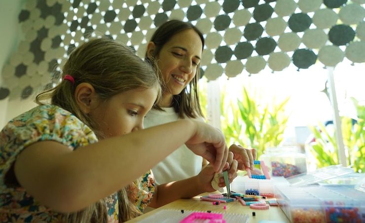 Foto la maestra en el taller enseñó a dos chicas cómo montar un termo mosaico.