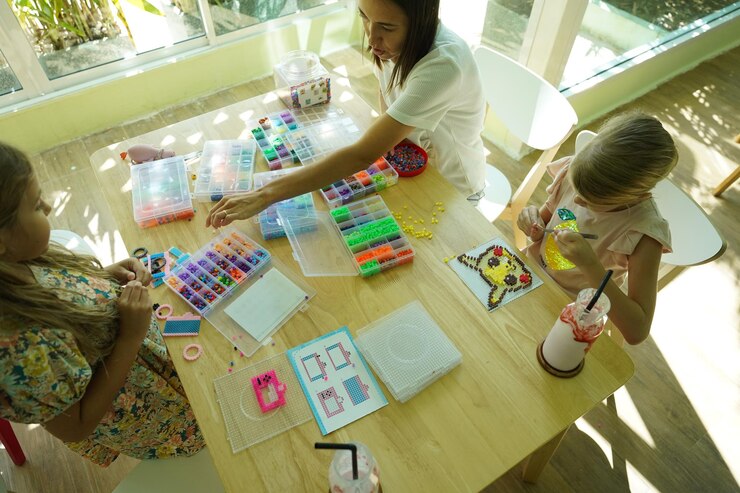 Foto la maestra en el taller enseñó a dos chicas cómo montar un termo mosaico.