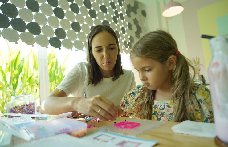 Foto la maestra en el taller enseñó a dos chicas cómo montar un termo mosaico.