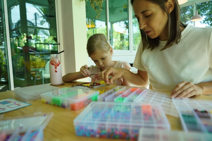 Foto la maestra en el taller enseñó a dos chicas cómo montar un termo mosaico.