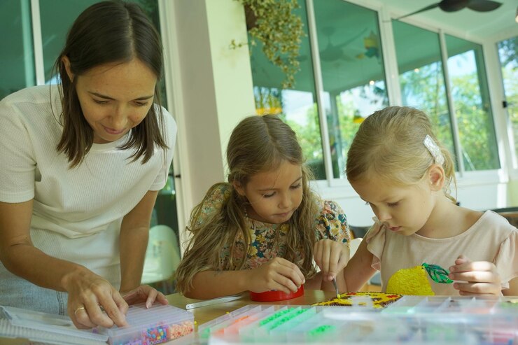 Foto la maestra en el taller enseñó a dos chicas cómo montar un termo mosaico.