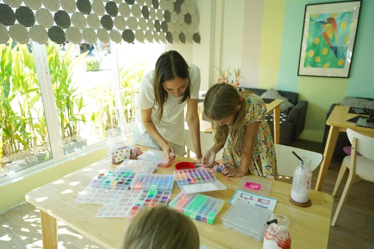 Foto la maestra en el taller enseñó a dos chicas cómo montar un termo mosaico.