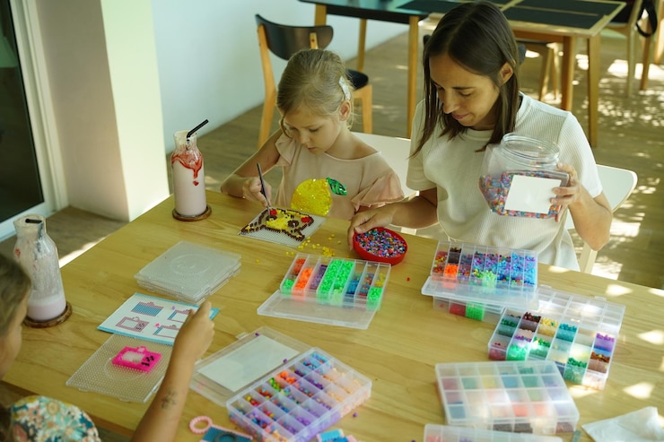 Foto la maestra en el taller enseñó a dos chicas cómo montar un termo mosaico.