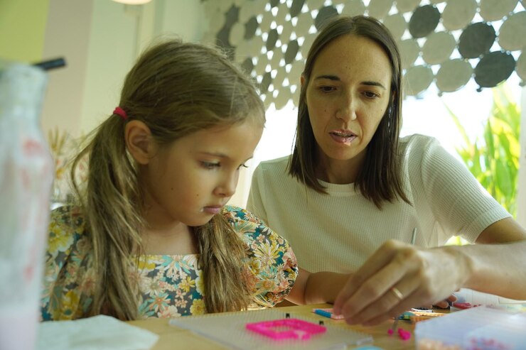 Foto la maestra en el taller enseñó a dos chicas cómo montar un termo mosaico.