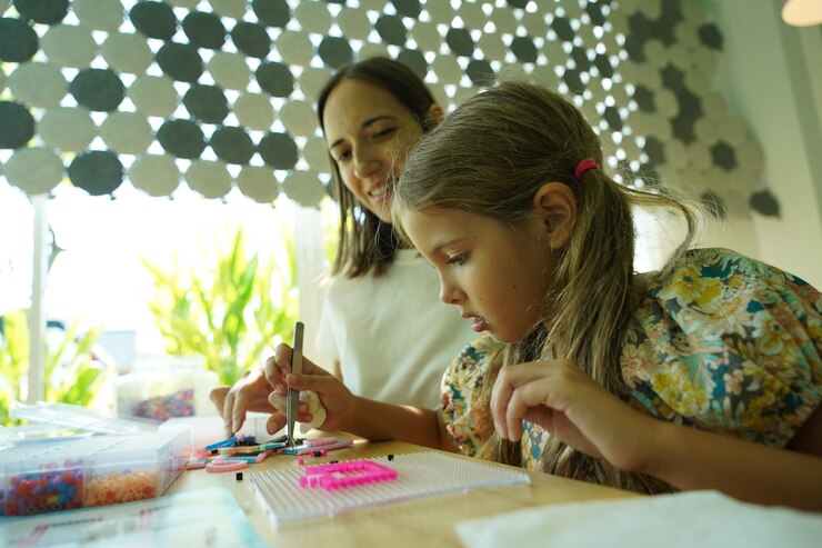 Foto la maestra en el taller enseñó a dos chicas cómo montar un termo mosaico.