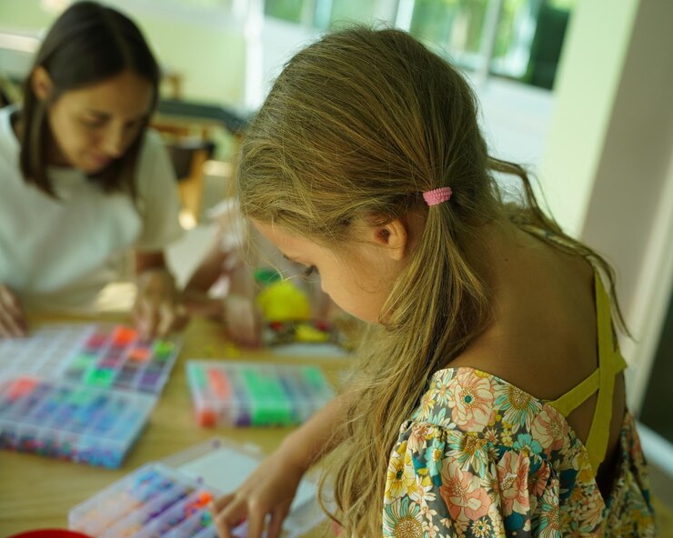 Foto la maestra en el taller enseñó a dos chicas cómo montar un termo mosaico.