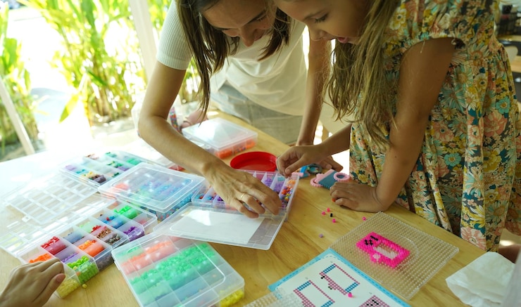 Foto la maestra en el taller enseñó a dos chicas cómo montar un termo mosaico.