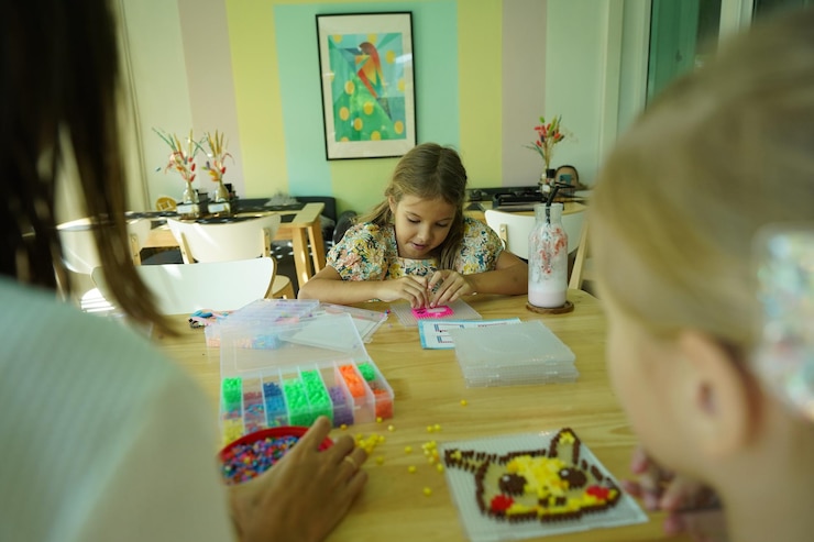 Foto la maestra en el taller enseñó a dos chicas cómo montar un termo mosaico.