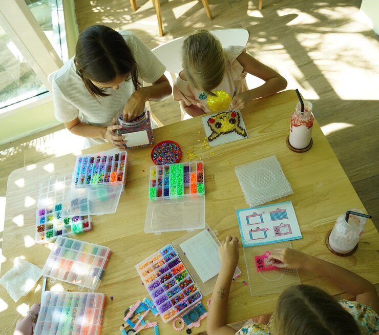 Foto la maestra en el taller enseñó a dos chicas cómo montar un termo mosaico.
