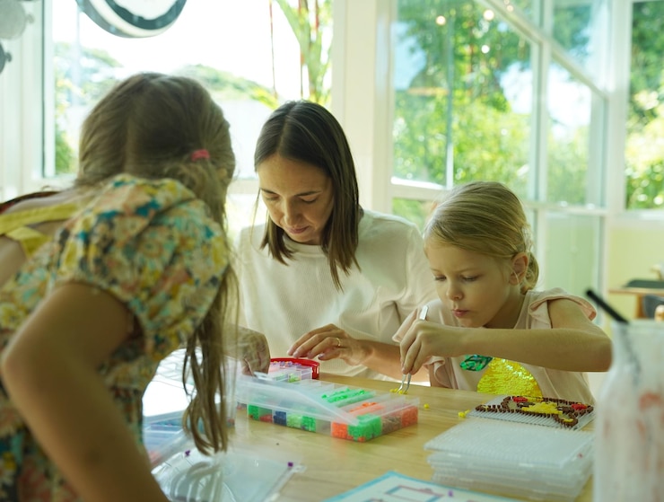 Foto la maestra en el taller enseñó a dos chicas cómo montar un termo mosaico.