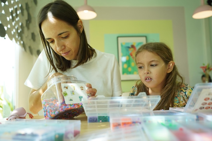 Foto la maestra en el taller enseñó a dos chicas cómo montar un termo mosaico.