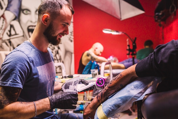 Foto maestro adulto en estudio de tatuajes