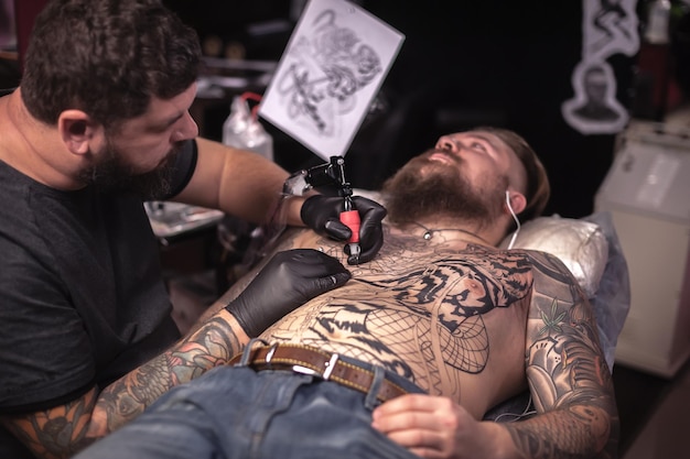 Maestro del arte del tatuaje durante una sesión de tatuador