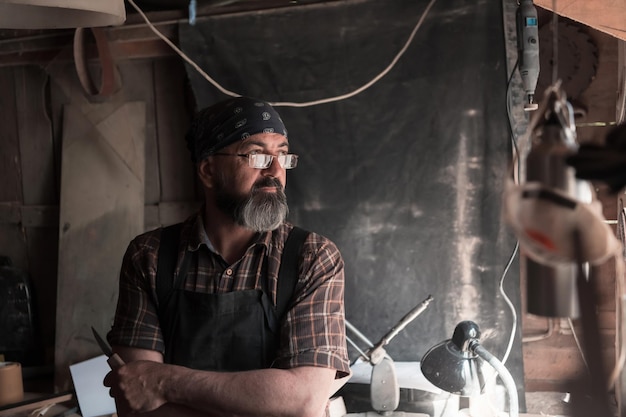 Maestro artesanal de cucharas en su taller con productos y herramientas de madera hechos a mano. foto de alta calidad