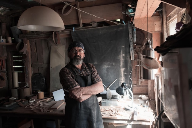 Maestro artesanal de cucharas en su taller con productos y herramientas de madera hechos a mano. foto de alta calidad